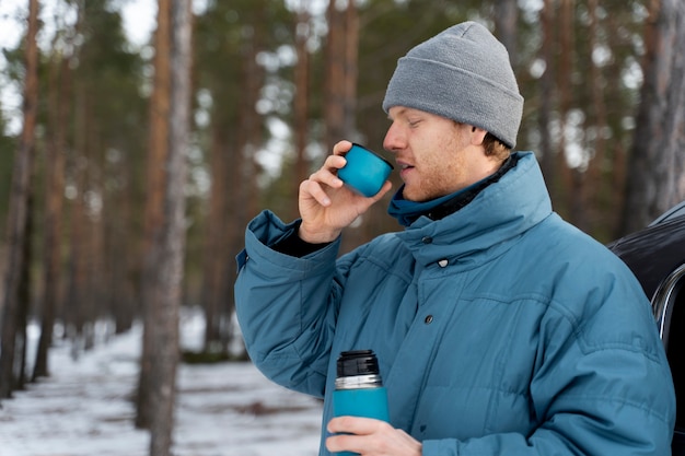 Free photo close up on man enjoying hot drink while on winter trip