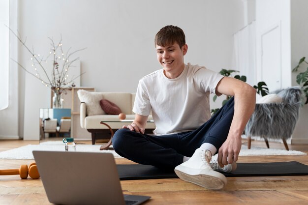 オンラインインストラクターの後に運動している男性のクローズアップ