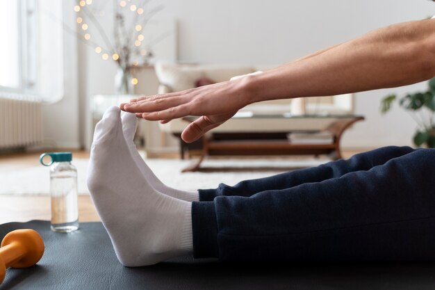 Close up on man exercising after online instructor