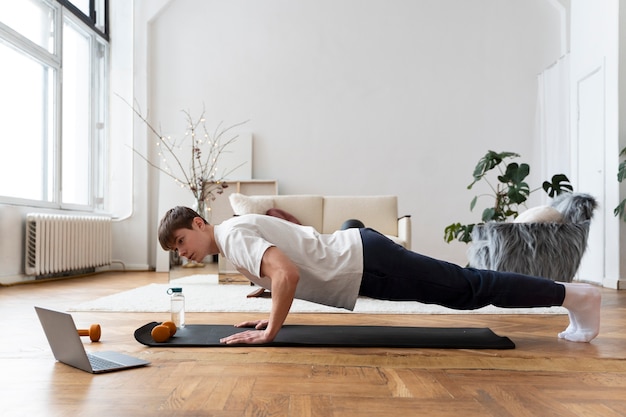 Close up on man exercising after online instructor