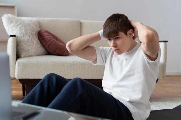 Close up on man exercising after online instructor