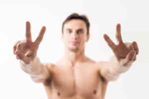 Free photo close up man gesturing peace sign