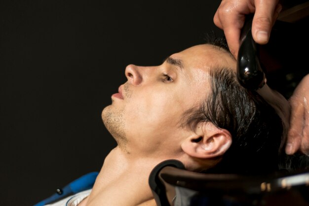 Close up man getting hair washed