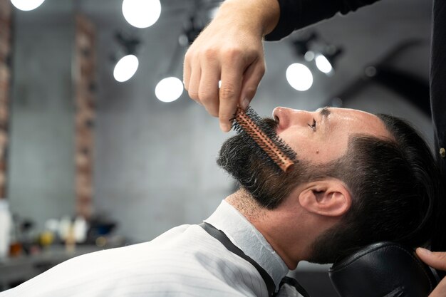 Close up man getting his beard groomed