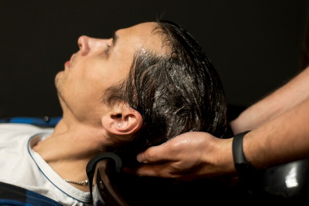 Close up man getting his hair washed