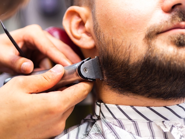 Free photo close-up of man getting his sideburns cut