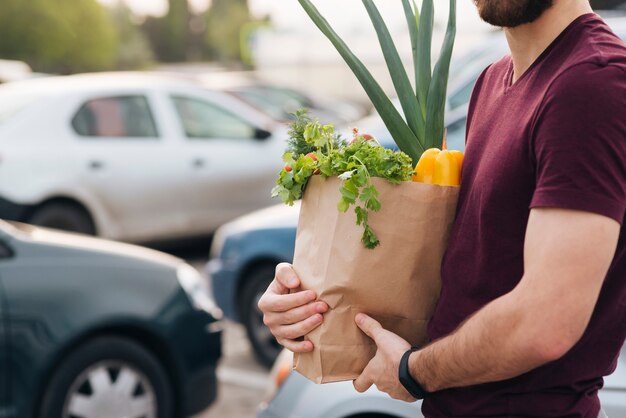 Close-up man holding bag with groceries