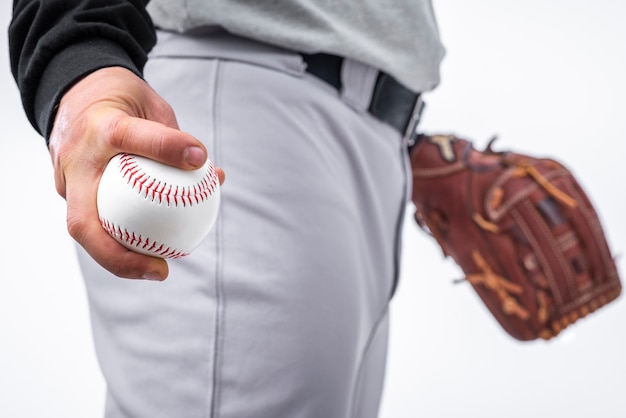 Close-up of man holding baseball and glove