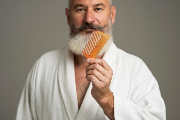 Close up man holding beard comb