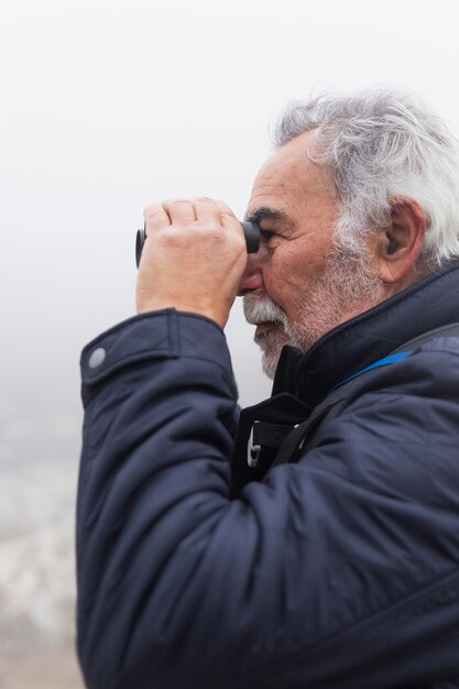 Close up man holding binoculars