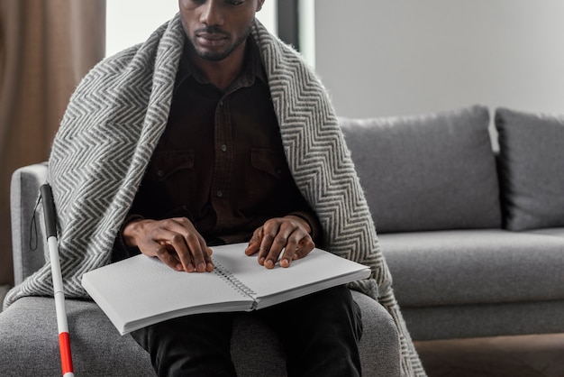 Free photo close up man holding braille notebook