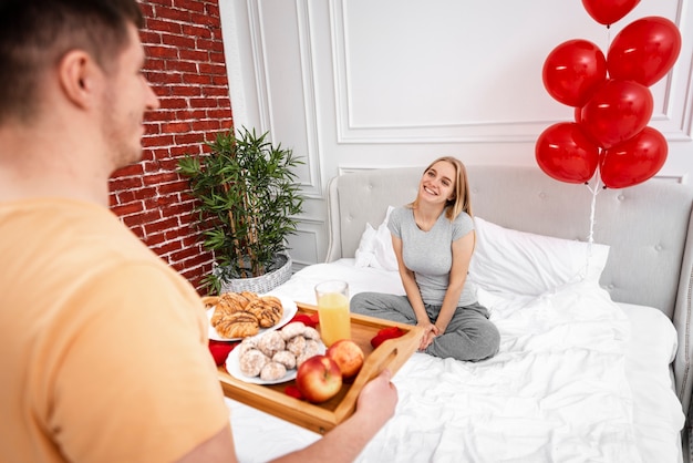 Foto gratuita prima colazione della tenuta dell'uomo del primo piano per l'amica