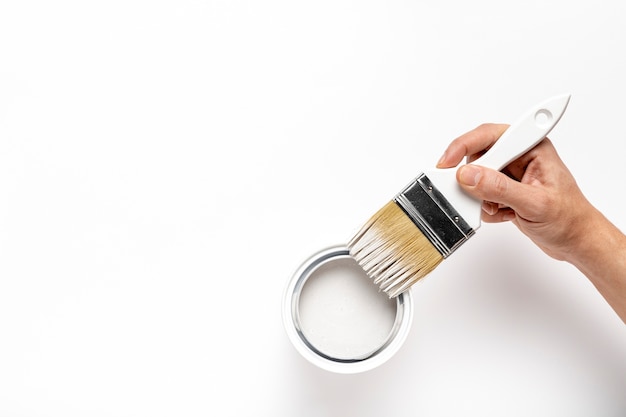 Close-up man holding brush with white paint