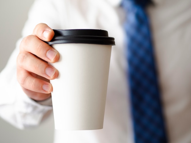 Крупным планом мужчина держит чашку кофе макет