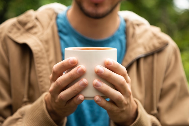 コーヒーカップを保持している男のクローズアップ