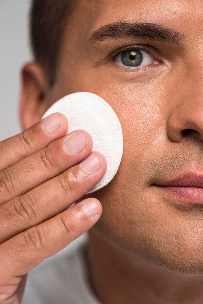 Close-up man holding cotton pad