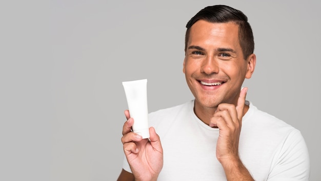 Close-up man holding cream container