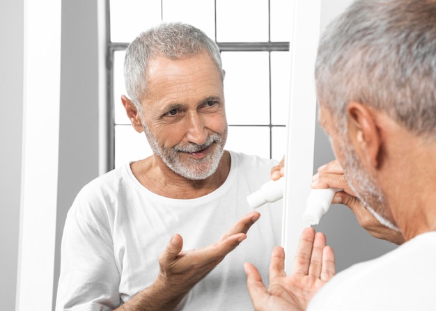 Close-up man holding cream container