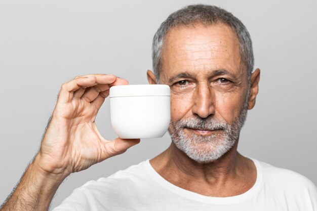 Close-up man holding cream container