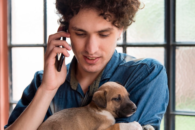 かわいい犬を保持しているクローズアップ男