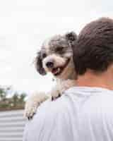 Foto gratuita uomo del primo piano che tiene cane sveglio