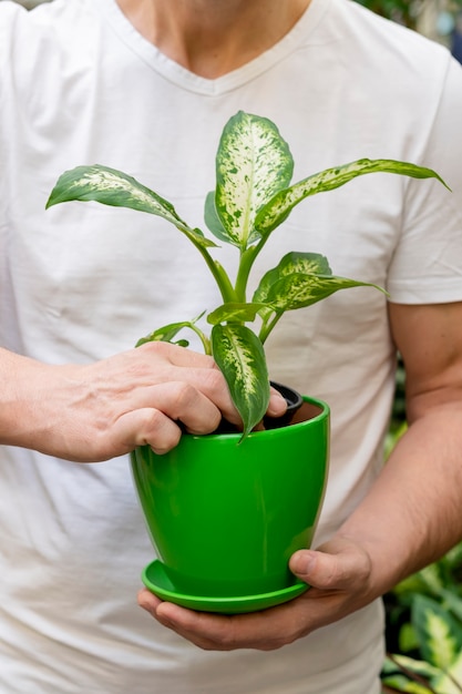 植物と植木鉢を持ってクローズアップ男