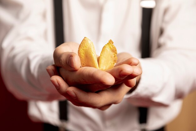 Close-up of man holding fortune cookie for chinese new year