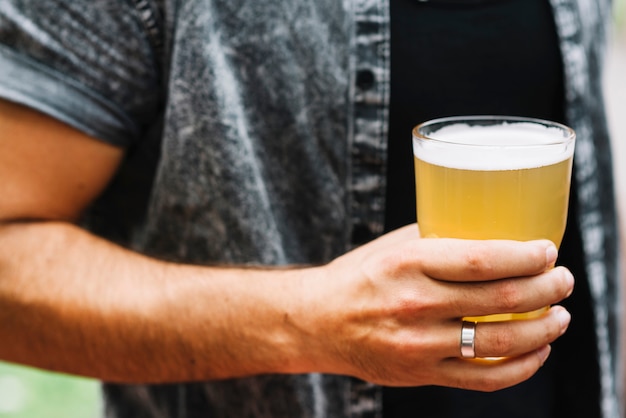 Close-up of man holding glass of beer