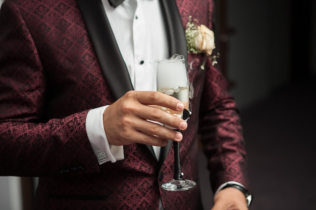Крупным планом человека, держащего в руке бокал шампанского с дымом от него