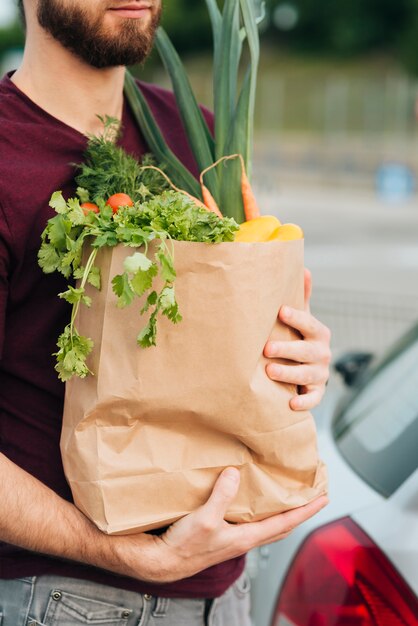 Крупным планом мужчина держит продуктовый мешок