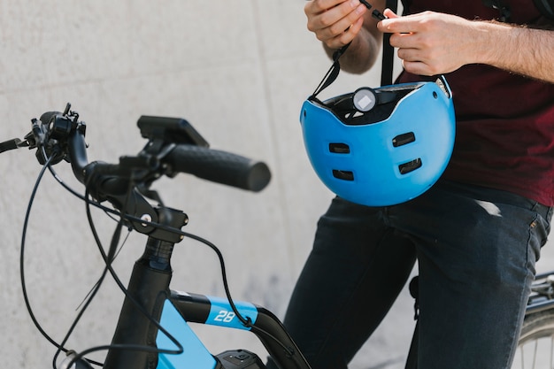 Free photo close up man holding helmet on bicycle