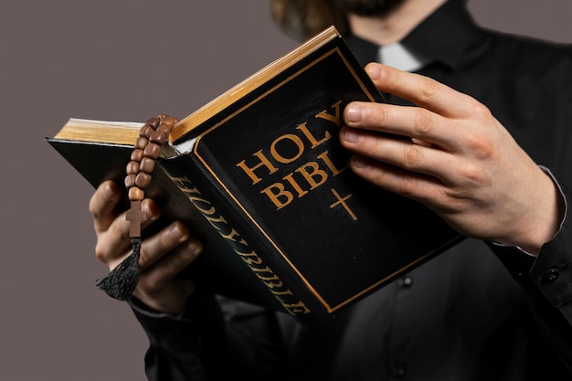 Free photo close up man holding holy bible