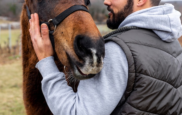 Close-up man holding horse