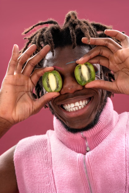 Free photo close up man holding kiwi slices