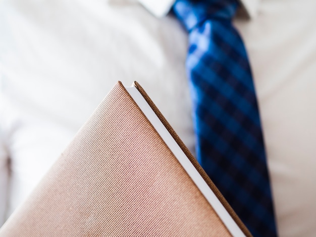 Free photo close-up man holding a leather notebook