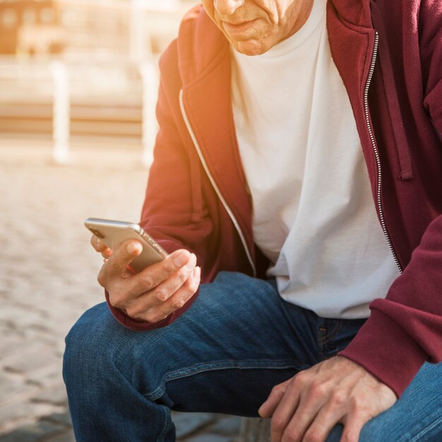 携帯電話を手にしている男のクローズアップ