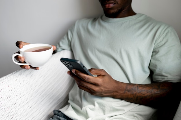 Close up man holding phone and cup