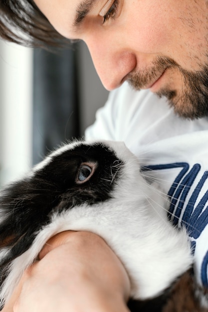 Free photo close up man holding rabbit