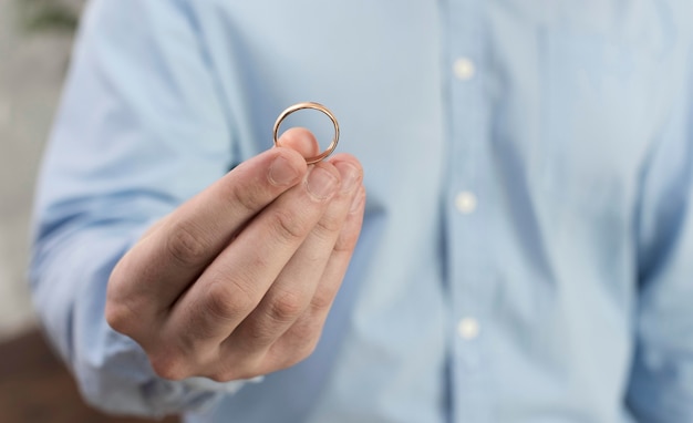 Close-up man holding wedding ring