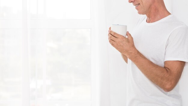 Free photo close-up man holding a white mug