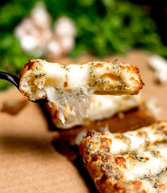 Close up of man holds a piece of turkish pastry stuffed with cheese