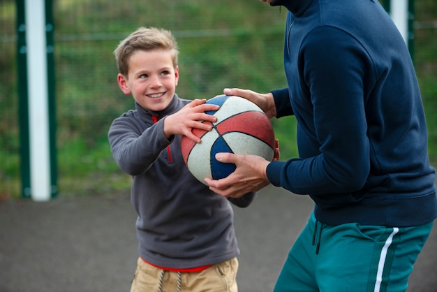 Close up man and kid holding ball