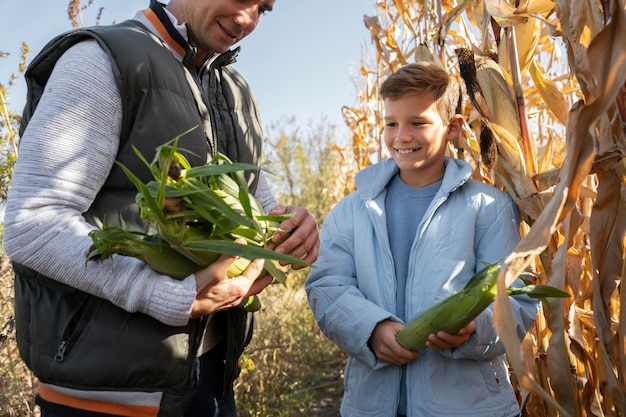 Крупным планом мужчина и ребенок, держащий кукурузу
