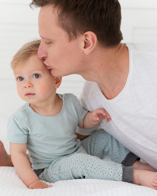 Free photo close up man kissing toddler