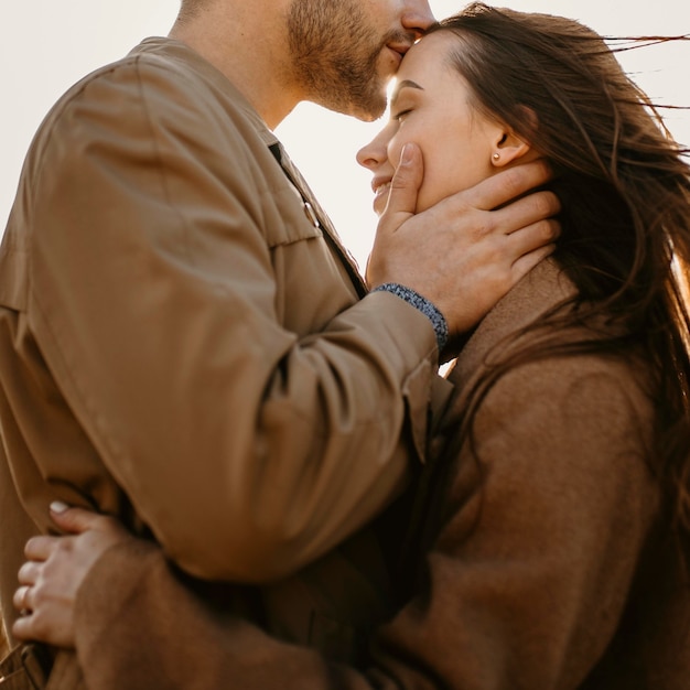 Close-up man kissing woman on forehead