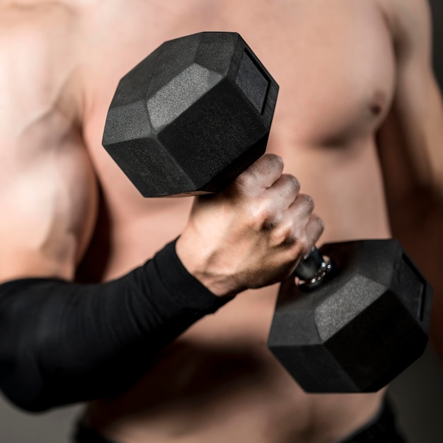 Free photo close-up man lifthing  weights