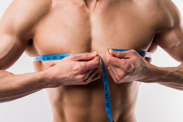 Free photo close-up of man measuring muscled chest
