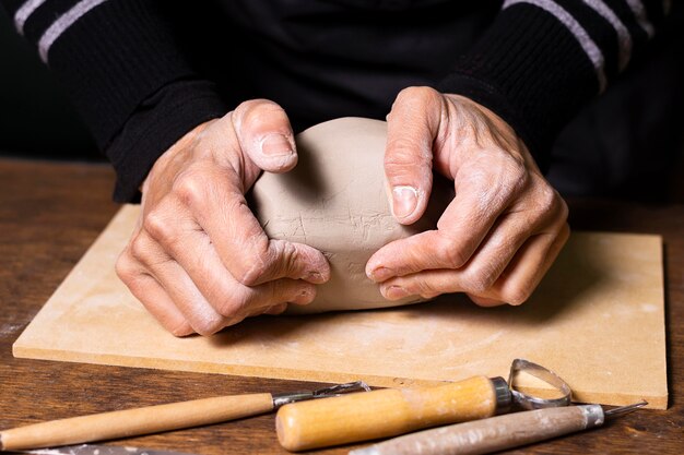 Close-up man mixing clay