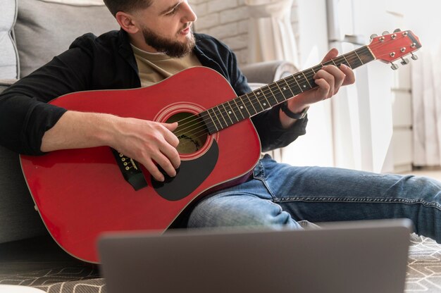 Close up man playing guitar on floor