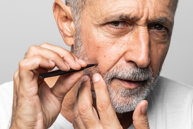 Close-up man plucking his face